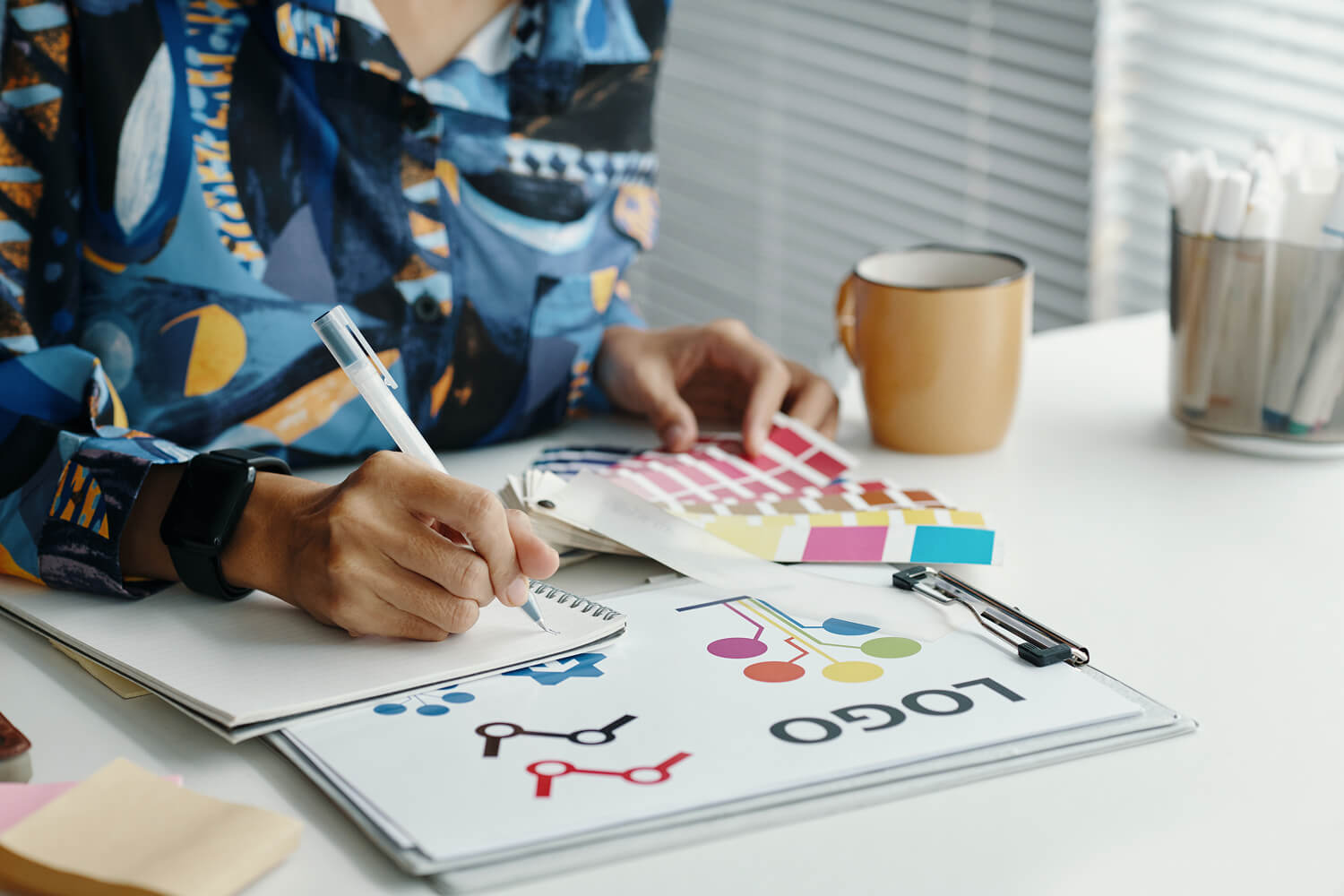 Diseñadora revisando bocetos de logotipo: qué mirar al elegir agencia de marketing